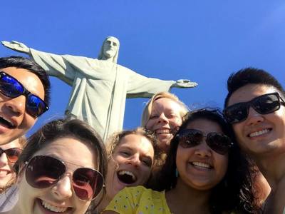 Seven Harvard-Radcliffe Collegium Musicum singers in front of Christ the Redeemer Statue in Brazil.