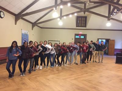 Collegium choir members standing in straight line and posing for a picture in large gymnasium while on choir retreat.
